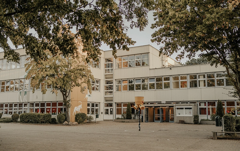 Hier ist ein  Foto der Schule mit dem Eingangsbereich zu sehen.